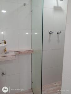 a shower with a glass door next to a sink at Hotel Medellin Kapital in Medellín
