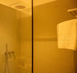 a bathroom with a shower and a towel on a wall at Casa da Carvoaria in Vila Real +22 photos