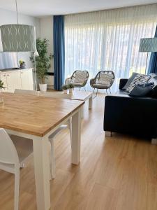 sala de estar con mesa y sofá en Kaap 10, en Hollum