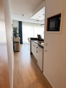 a kitchen with a counter and a tv on the wall at Kaap 10 in Hollum