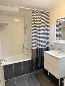 a bathroom with a tub and a sink and a shower at Kaap 10 in Hollum