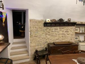 a kitchen with a stone wall and a table and a stairway at Il Carpino luxury historic apartment in Carpineto Romano