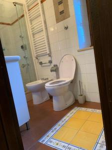 a bathroom with a toilet and a glass shower at Il Carpino luxury historic apartment in Carpineto Romano