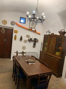 a dining room with a wooden table and a chandelier at Il Carpino luxury historic apartment in Carpineto Romano