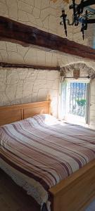 a bedroom with a large bed with a window at La petite tanière in Fontan