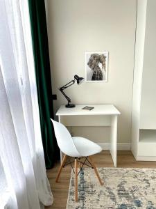 - un bureau blanc avec une lampe et une chaise blanche dans l'établissement ЖК 4 seasons, рядом ТРЦ Mega по Розыбакиева, à Almaty