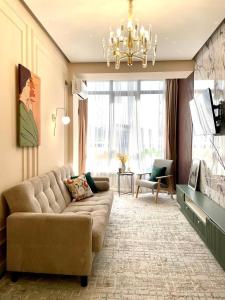 - un salon avec un canapé et un lustre dans l'établissement ЖК 4 seasons, рядом ТРЦ Mega по Розыбакиева, à Almaty