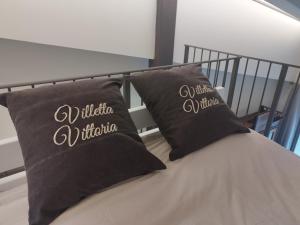 a bed with two black pillows on it at Villetta Vittoria Country House. La depandance in Pennabilli