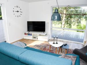 ein Wohnzimmer mit einem blauen Sofa und einem TV in der Unterkunft Holiday apartment Elbe 