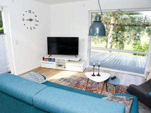 a living room with a blue couch and a tv at Holiday apartment Elbe in Westende