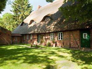 a large brick house with a thatched roof at Holiday apartment Trulich Hoff 