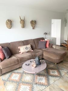 ein Wohnzimmer mit einem braunen Sofa und einem Tisch in der Unterkunft "Casa Diego"Ferienhaus mit Garten in Bielefeld
