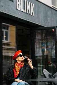 een vrouw die aan een tafel zit te praten op een microfoon bij Hotel Blink in Valkenburg
