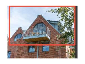 un bâtiment avec un balcon au-dessus dans l'établissement Boothäuser Living_art Wangerooge, à Wangerooge