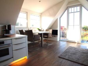 a kitchen and dining room with a table and chairs at Boothäuser Living_art Wangerooge in Wangerooge +17 photos
