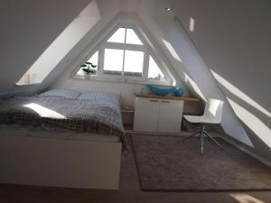 1 dormitorio con cama, escritorio y ventana en Boothäuser Living_art Wangerooge en Wangerooge
