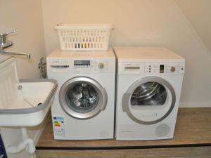 een wasruimte met 2 wasmachines en een wastafel bij Holiday apartment Langeoogtraum in Langeoog