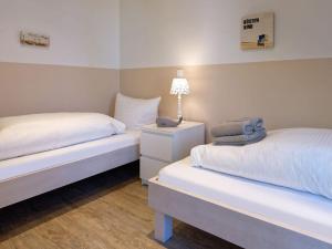 een slaapkamer met 2 bedden en een lamp op een nachtkastje bij Holiday apartment Langeoogtraum in Langeoog