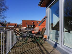 een terras met 2 stoelen en een tafel op een balkon bij Holiday apartment Langeoogtraum in Langeoog