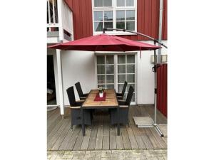 グレートジールにあるHeimathafen Greetsielの木製テーブル(赤い傘付)
