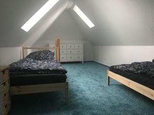 a attic bedroom with two beds and a dresser at Holiday apartment Ponywiese in Ihlow