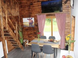 ein Esszimmer mit einem Tisch mit Stühlen und einem TV in der Unterkunft Eifel Chalet holiday apartment 