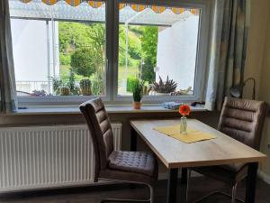 einen Tisch und Stühle vor einem Fenster in der Unterkunft Holiday apartment Lenz in Kröv