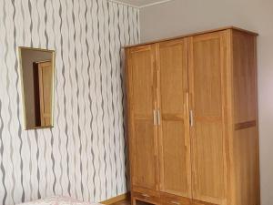 ein Schlafzimmer mit einem Holzschrank und einem Spiegel in der Unterkunft Holiday apartment Lenz in Kröv