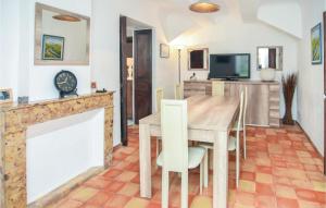 Les Figons的住宿－Gorgeous Home In Aix En Provence With Kitchen，一间带木桌和壁炉的用餐室