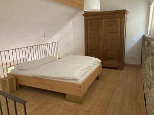 Un dormitorio con una cama y un armario de madera. en Lindenblatt ' right, en Urbar