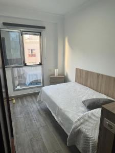 a bedroom with a bed and a large window at Acogedor apartamento con piscina yedae in Gáldar