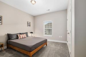 een slaapkamer met een bed en een raam bij Modern New Build 4BR 4BA Condo w Garage and Patio in Wyoming
