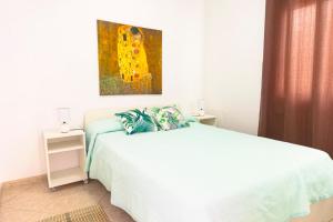 1 dormitorio con 1 cama y una pintura en la pared en Apartamento ático, en Gran Tarajal