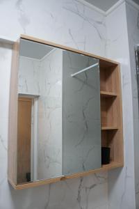 a glass medicine cabinet in a bathroom with marble at DeLuxe Ap Almaty Центр in Almaty +30 photos