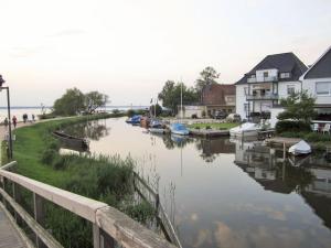 Un río con barcos al lado de las casas. en Dornbusch Apartment 1, en Steinhude