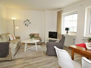 una sala de estar con un sofá y una mesa en Dornbusch Apartment 1, en Steinhude