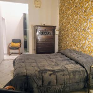 um quarto com uma cama e uma cómoda em madeira em La Casetta di Oppi em Nápoles