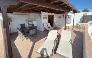 a patio with a table and white chairs at Casa Pedro in Costa Teguise