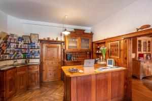 a kitchen with wooden cabinets and a desk with a laptop at Weisses Kreuz - Crusch Alva in Samedan