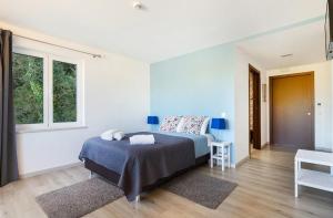 a bedroom with a bed and two windows at Olhos d´Água in Alcanena