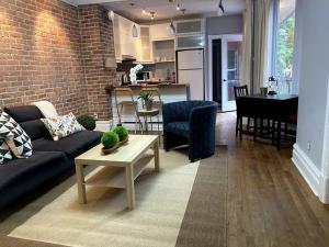 a living room with a couch and a table and a kitchen at Irresistible 2 bedroom condo, excellent location in Montréal