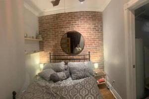 a bedroom with a bed and a brick wall at Irresistible 2 bedroom condo, excellent location in Montréal