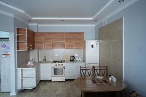 a kitchen with white appliances and a wooden table at Квартира in Kokshetau