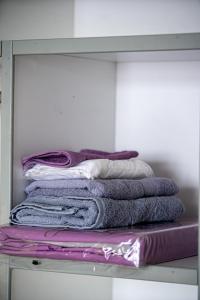 a pile of towels are stacked on a shelf at Квартира in Kokshetau