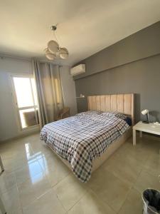 1 dormitorio con cama, mesa y ventana en 适家华人民宿 en El Cairo