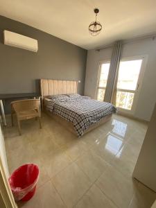 1 dormitorio con 1 cama, 1 silla y 1 ventana en 适家华人民宿, en El Cairo