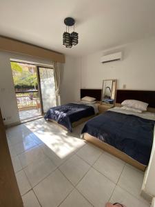 1 dormitorio con 2 camas y ventana en 适家华人民宿, en El Cairo