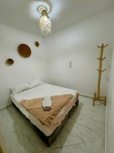 塔哈佐特La Banane House的卧室里有一张床，墙上挂着一个十字架