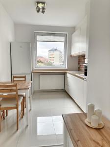 格但斯克的住宿－Przystanek Morena，白色的厨房,配有桌子和窗户