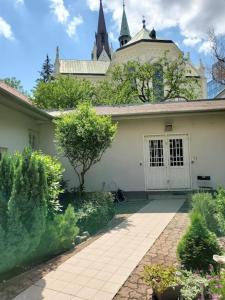 a white house with a walkway in front of it at Blumental apartment, garden, AC in Bratislava